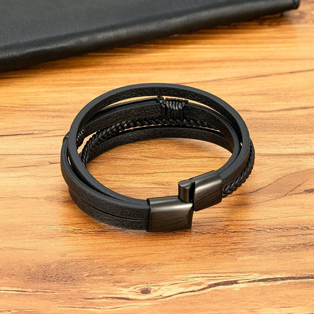 Pulseira masculina de couro preta com fecho metálico sobre superfície de madeira