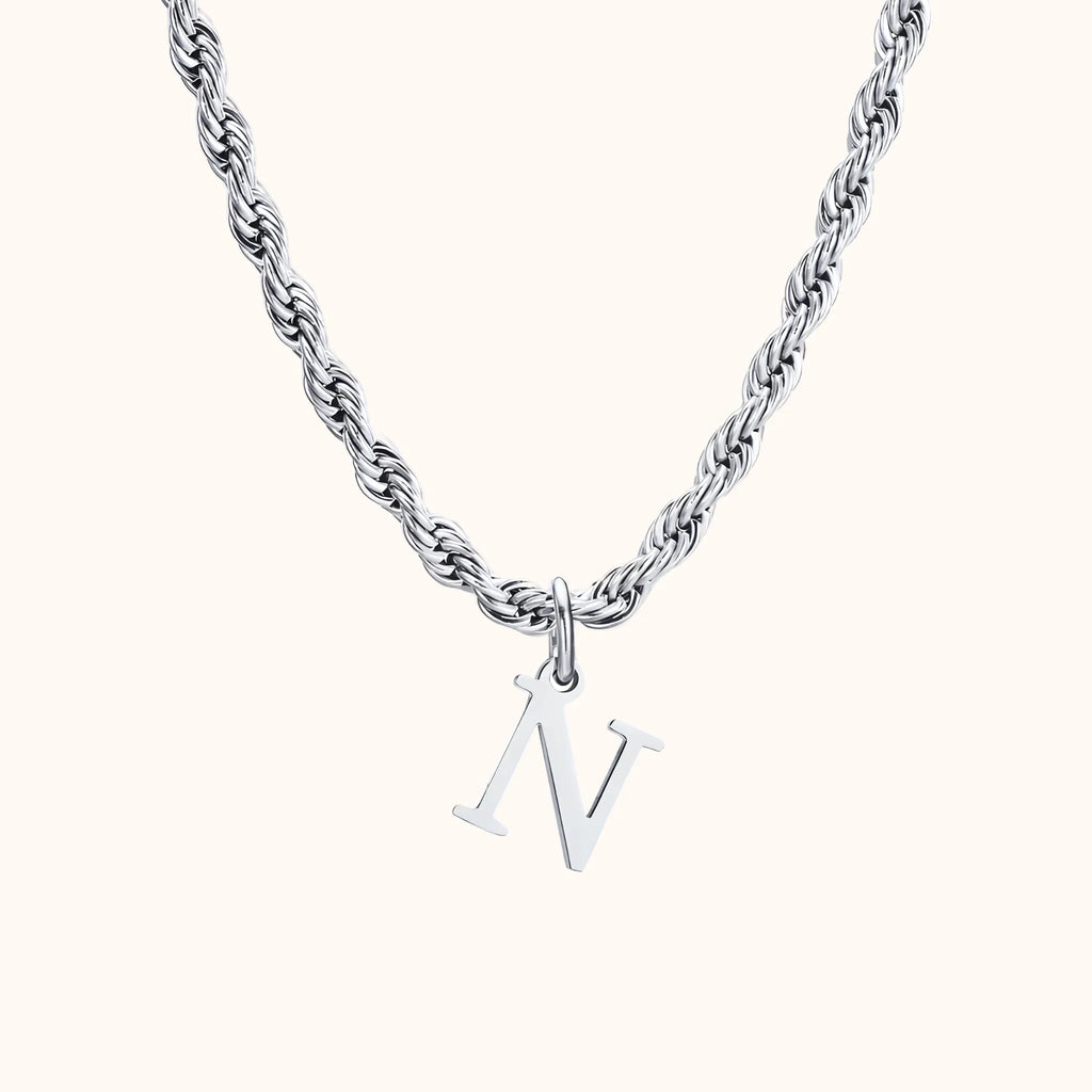 Colar de aço com pingente letra N em fundo cinza e base branca da marca Vnox