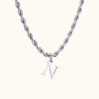 Colar de aço com pingente letra N em fundo cinza e base branca da marca Vnox